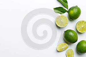 Lime fruits with green leaf and cut in half slice isolated on white background. Top view. Flat lay with copy space