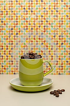 Lime green coffee cup and saucer filled with fresh coffee beans