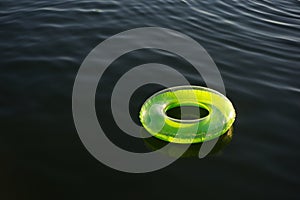 Lime green inflatable ring floating on dark water