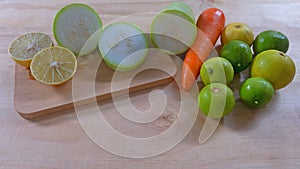 Lime and Green Winter Melon sliced half on wooden cutting board, carrot and fresh limes on the wooden floor