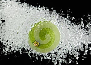 Lime (lemon) falling in water on black