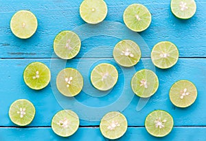 a Lime lemon are half cut on blue wooden background