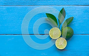 the Lime lemon are half cut on blue wooden background. copy space for graphic designer