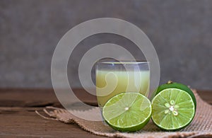 a Lime lemon and juice in transparent glass with sack cloth on r