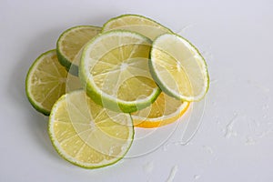 Lime, lemon - juicy ripe citrus pieces on a white background. Ingredients for making refreshing drinks and Mojito