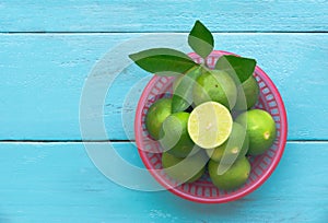 a Lime lemon in red bucket on blue wooden background. copy space