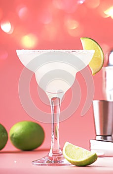 Lime margarita alcoholic cocktail with silver tequila, liqueur, lime juice, sugar syrup, salt and ice, festive trendy pink