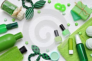 Lime mint composition of beauty threatment products in green colors on a white concrete background: shampoo, soap, bath salt, towe