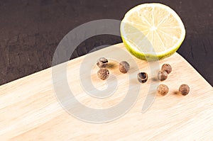 lime segment and spices on a empty cutting board/ lime segment and spices on a empty cutting board on a dark background