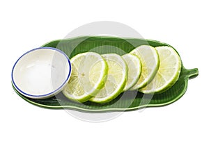 Lime sliced on a green plate with salt.