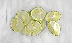 Lime slices and sections on a marble cutting board