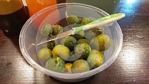 Lime and a small knife in a plastic bowl