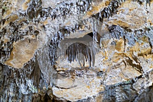 Lime stone stalactites in the cave - mineral formation that hangs from the cave's ceiling