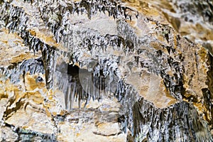 Lime stone stalactites in the cave - mineral formation that hangs from the cave's ceiling