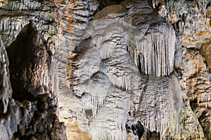 Lime stone stalactites in the cave - mineral formation that hangs from the cave's ceiling