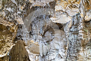 Lime stone stalactites in the cave - mineral formation that hangs from the cave's ceiling