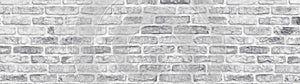 Lime washed shabby brick wall wide texture. Large light gray rustic brickwork wallpaper. Whitewashed panoramic vintage background