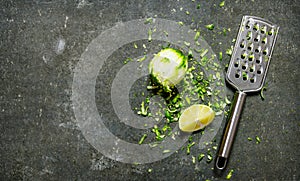 Lime zest and grater . Lime background. On stone table.