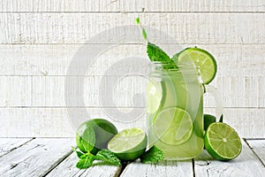 Limeade in a mason jar glass with a white wood background