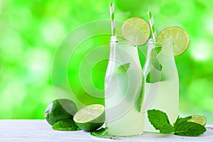 Limeade and mint in bottles with an outdoor background