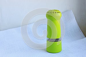 Limegreen peppermill. Kitchen equipment for grinding spices on a linen background. Front view