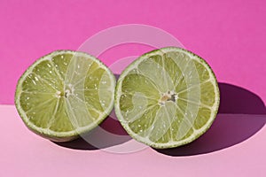 Limes cut open, pink background