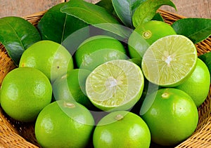 Limes with slices and leaves on white background