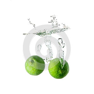 Limes splash on water on white background