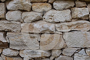 Limestone brick, masonry wall, rough uneven pieces of sandstone, backdrop texture background. White gray textured surface of