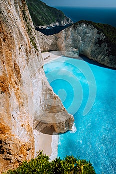 Limestone chalk colored like huge cliff rocks surrounding Navagio beach with Shipwreck and azure blue sea water