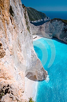 Limestone chalk colored like huge cliff rocks surrounding Navagio beach with Shipwreck and azure blue sea water