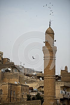 Limestone earth minaret of turkish mosque at sunset