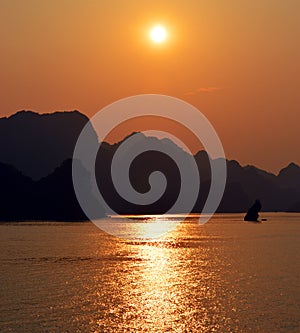 Limestone karsts in silhouette at sunset Halong Bay Vietnam