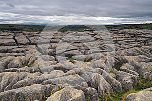 Limestone pavement high above Malham Cove against moody sky, Yorkshire Dales