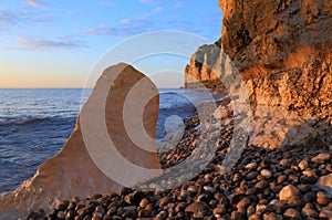 Limestone rock on the pebble beach at dawn