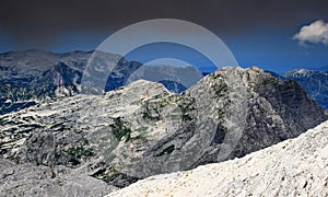 Limestone Veliko Spicje peak under dark clouds, Julian Alps