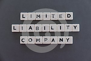 Limited liability company (LLC) word made of square letter word on grey background photo