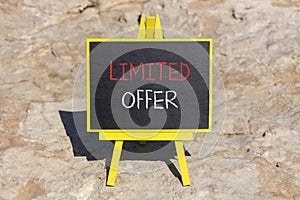 Limited offer symbol. Concept words Limited offer on beautiful black chalk blackboard. Beautiful sea stone beach background.