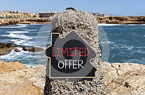 Limited offer symbol. Concept words Limited offer on beautiful black chalk blackboard. Beautiful stone sea blue sky background.