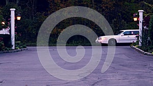 Limo car pulling into wedding venue parking lot through gate