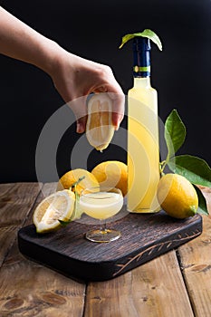 Limoncello in a bottle and a small shot with liquor. The traditional alcoholic beverage of Italy, from citrus. Fresh fruits and