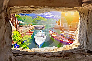 Limone sul Garda turquoise waterfront and boats view through stone window