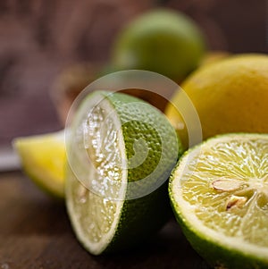 Green and yellow halves of fresh and juicy lemons. Close-up photo on dark background photo