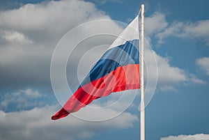 Limp Russian flag on the background of blue sky,