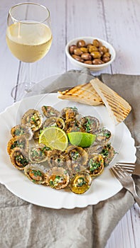 Limpets molluscs with lime and a glass of whine