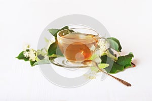 Linden tea on a white table in a glass cup.