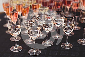 Line of alcohol setting on catering banquet table, bartender pouring beverages, row of different colored alcohol cocktails on a
