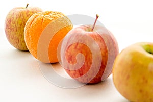 Line of apples with one orange