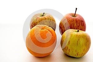 Line of apples with one orange