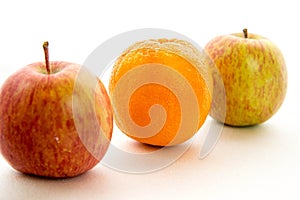 Line of apples with one orange